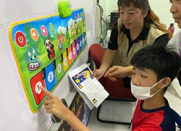 Crystal Tan volunteering with a young boy